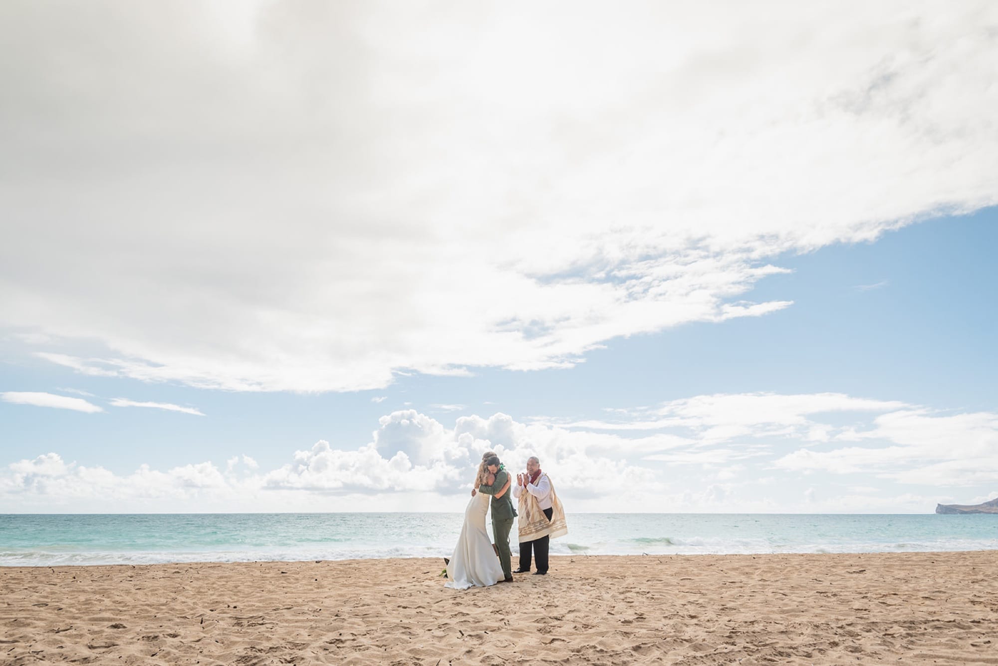 An elopement ceremony on the sand at Waimanalo Beach, the ocean behind