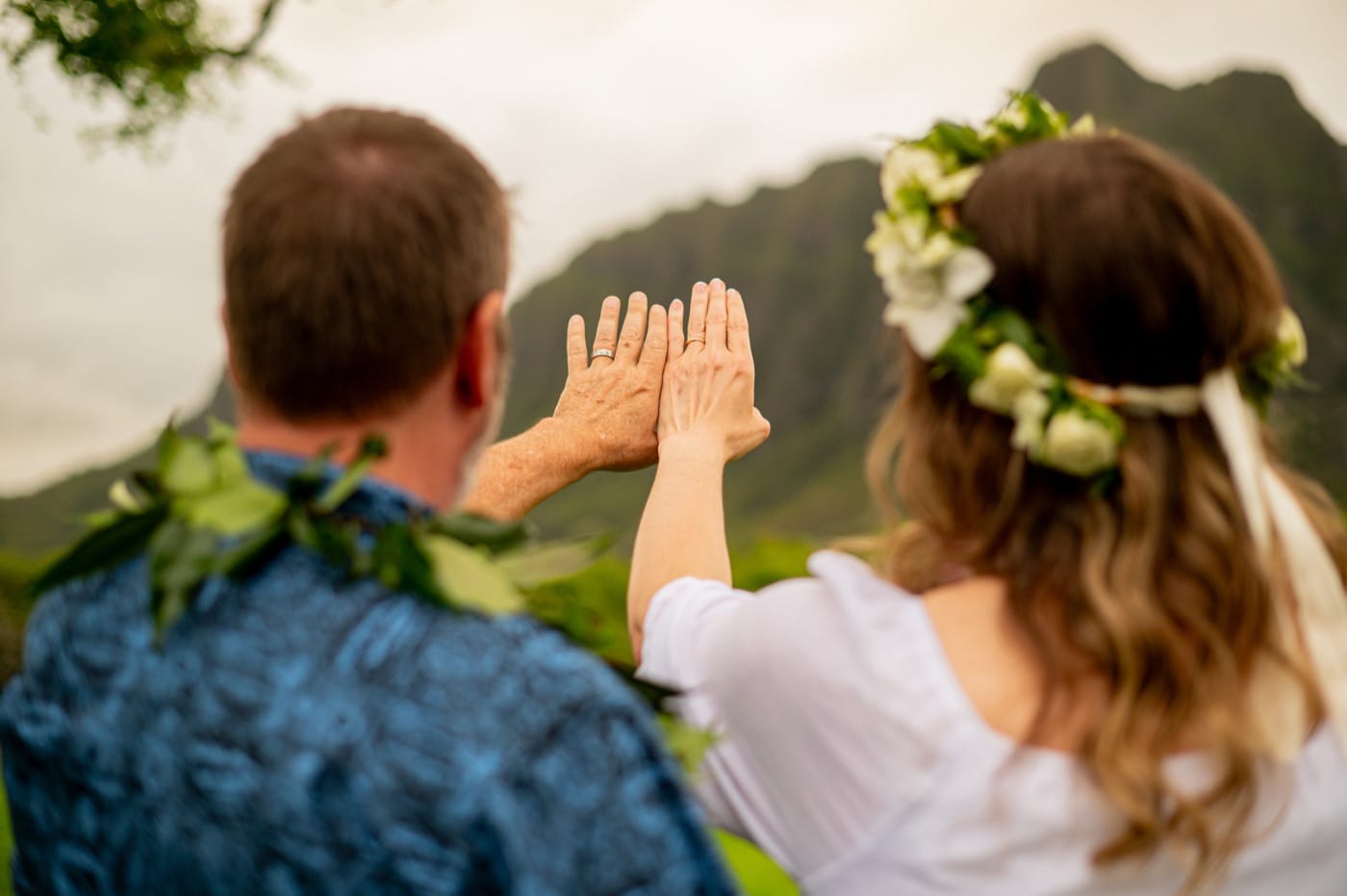 A couple at Kualoa, the mountains behind, on their Oahu elopement day