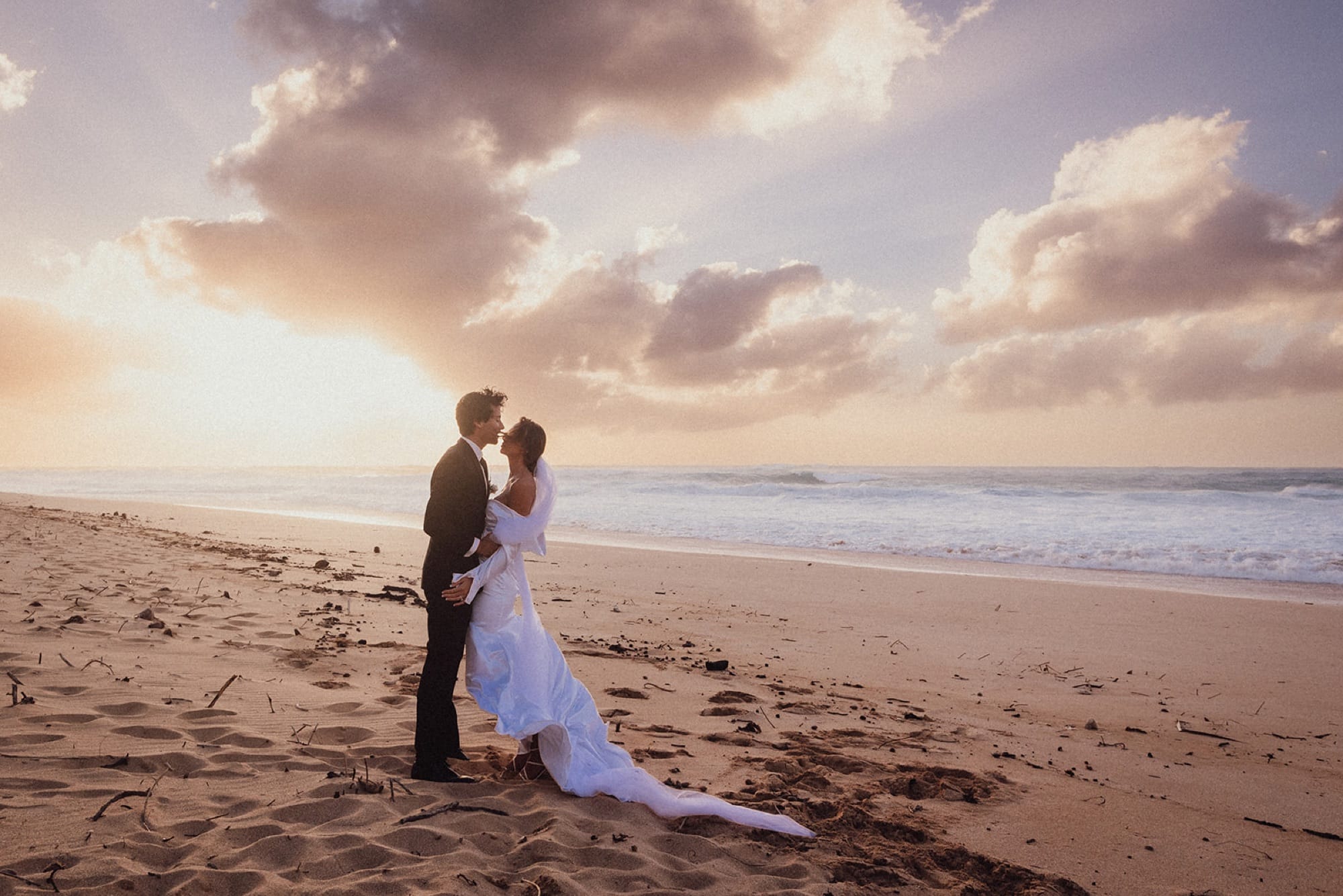 A couple on the sand at sunset on the North Shore of Oahu