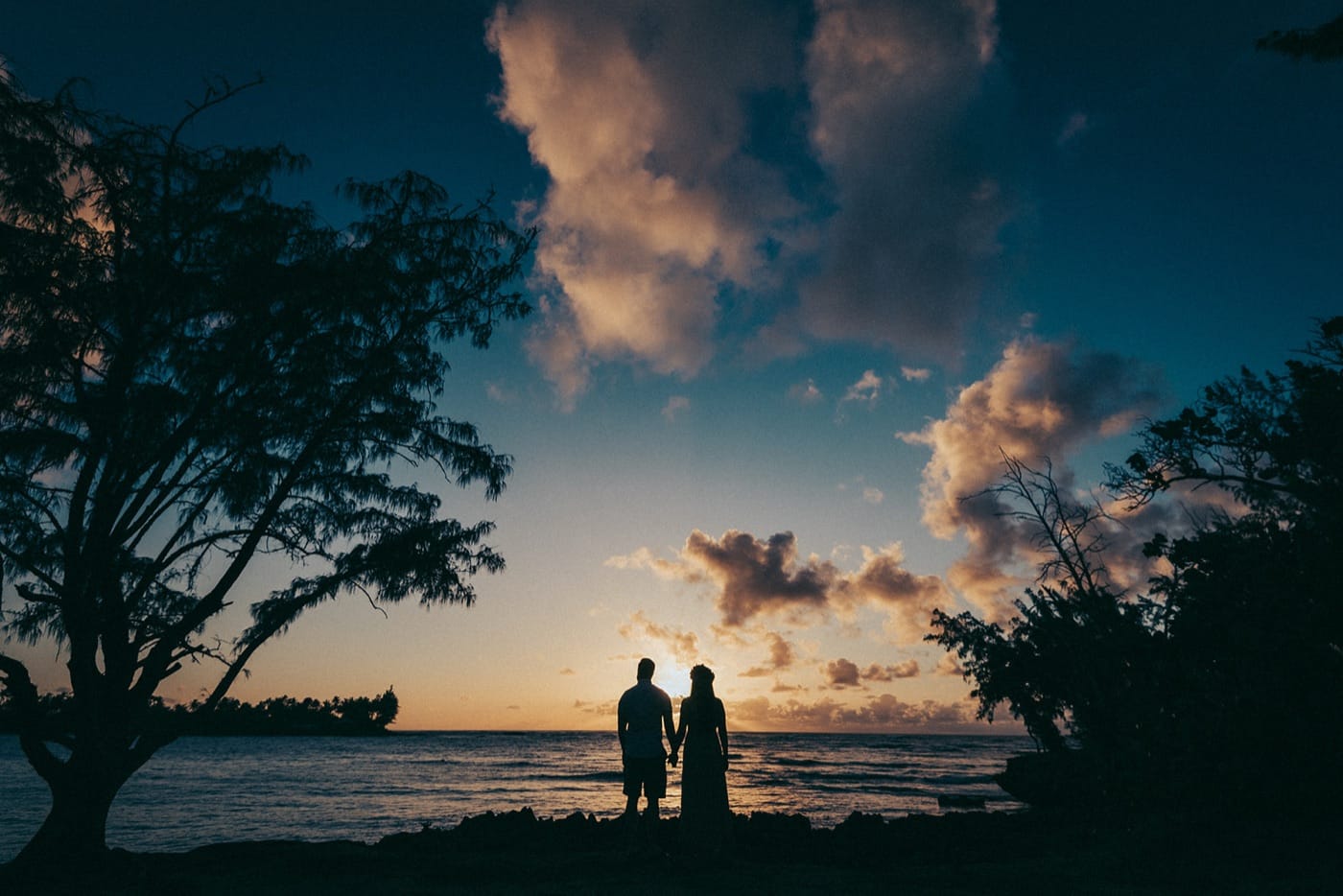 Two silhouettes at sunset at Kawela Bay