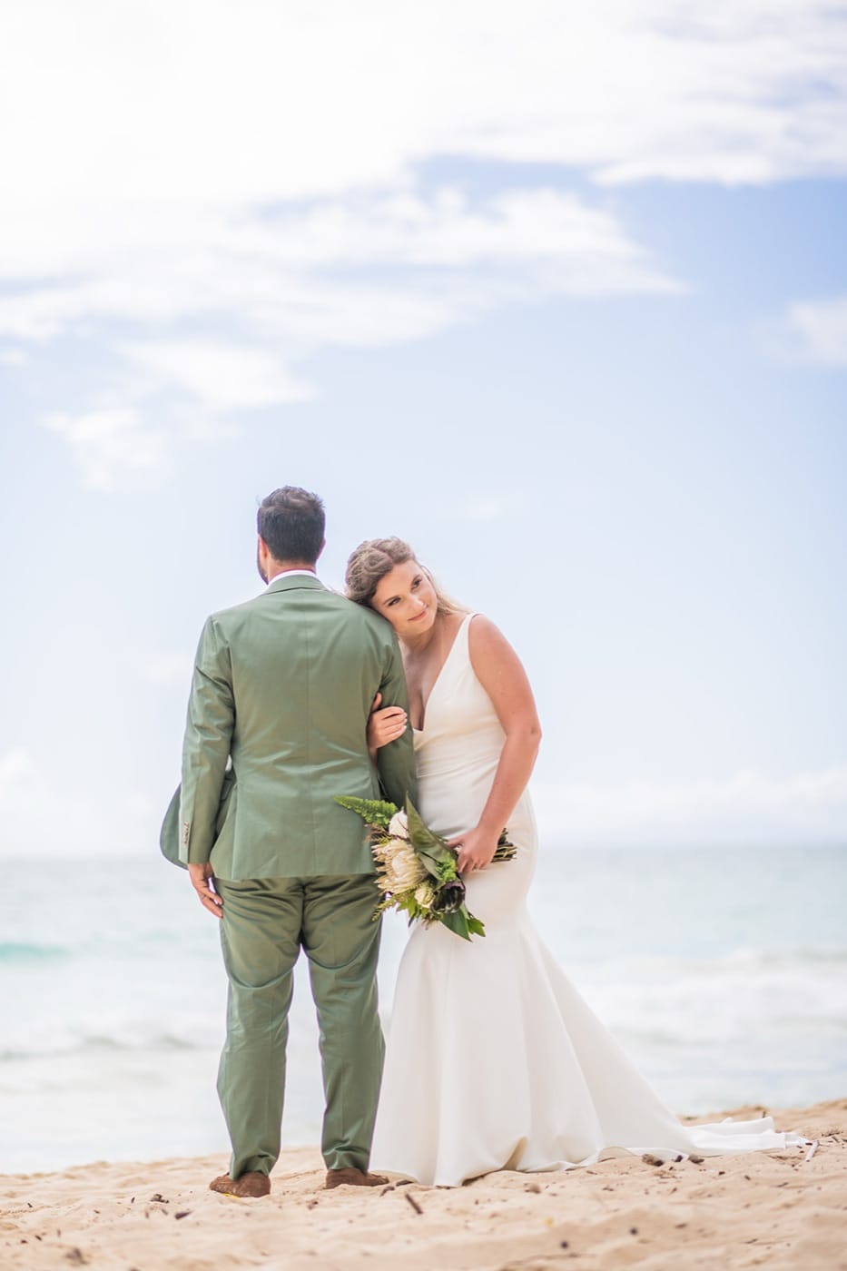 A couple holding each other on the sand at Waimanalo Beach
